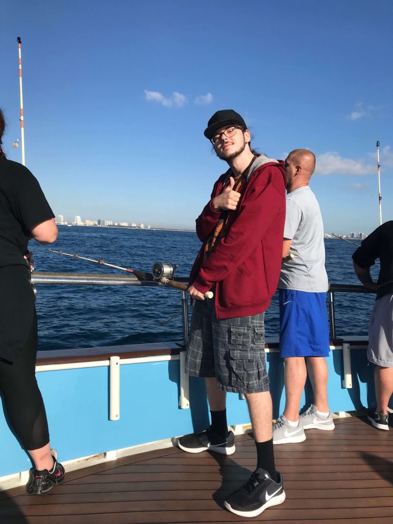 Client holding a game fish during deep sea fishing excursion